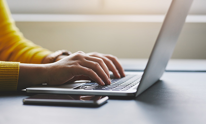 female typing on a laptop